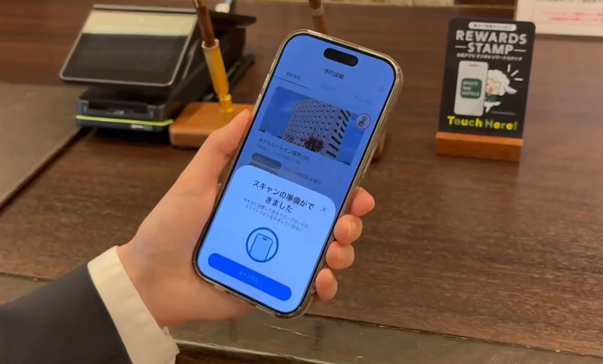 フロントでスマートフォンをかざしてスタンプを取得する様子
